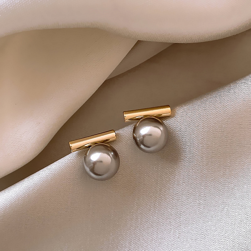 Elegante goldene Ohrringe mit dunklen Perlen